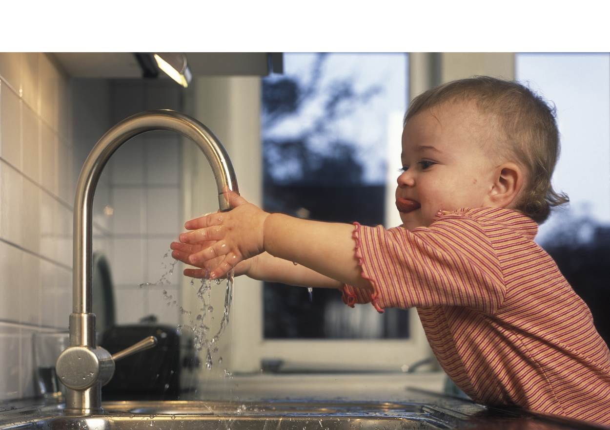 Een kindje wast haar handen onder de kraan