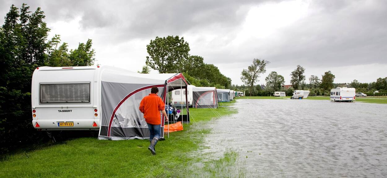 Man naast camper tijdens wateroverlast