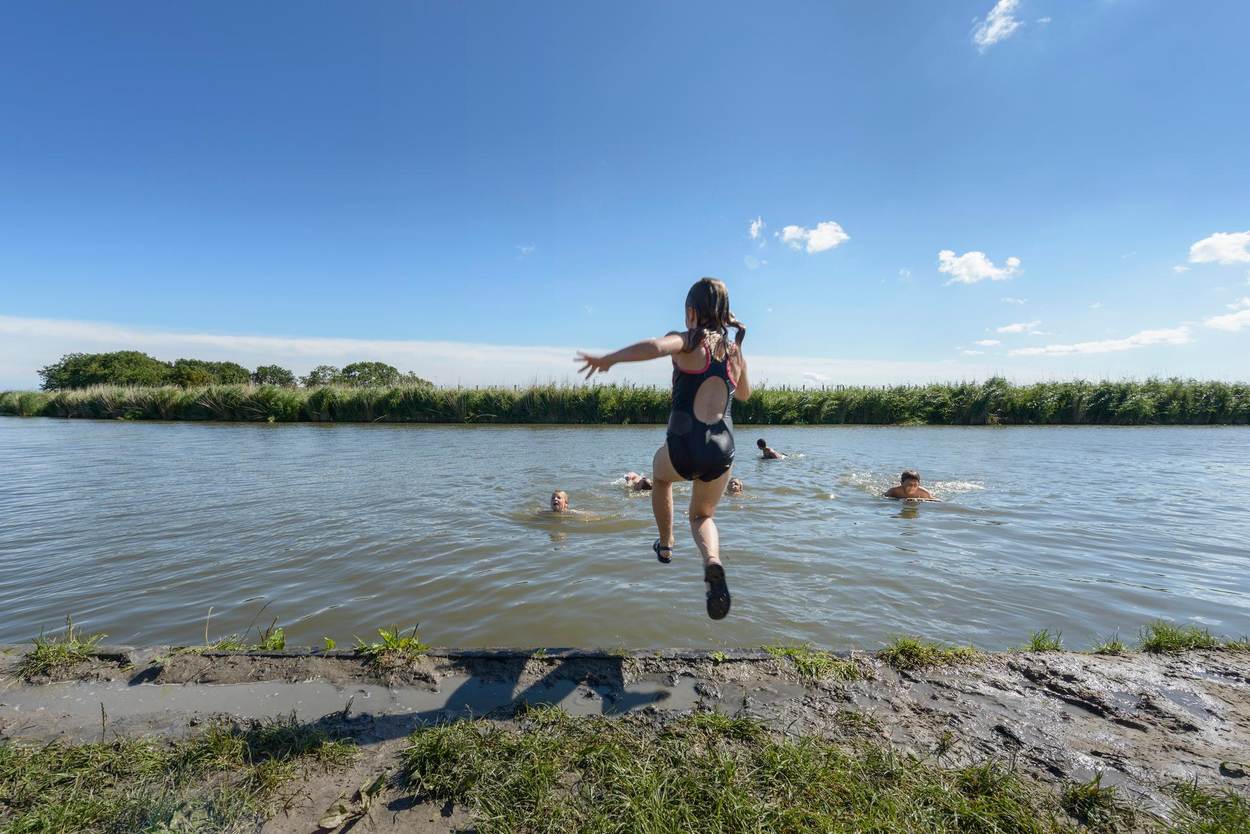 Kinderen springen in het water.