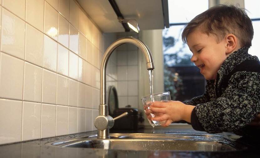 kind vult glas water bij kraan