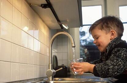 Jongetje vult glas met water uit de kraan