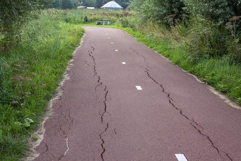 Barsten in het asfalt van een fietspad door droogte