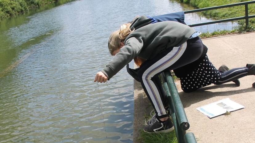 meisje terwijl ze watermetingen uitvoert in rivier