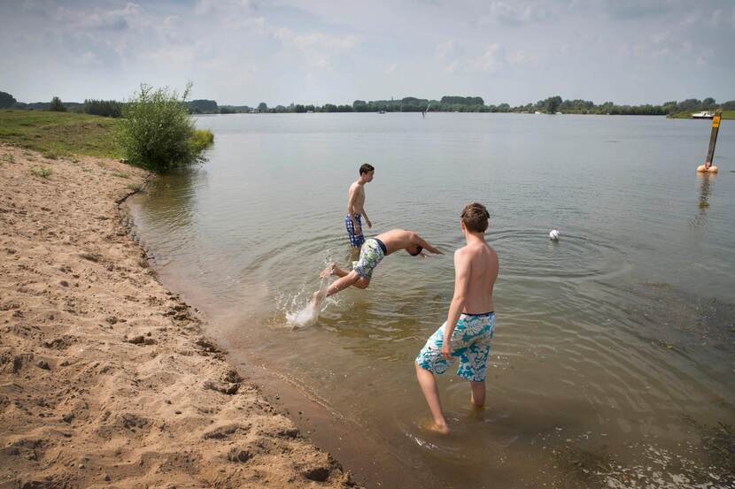 kinderen spelen op strandje van meer