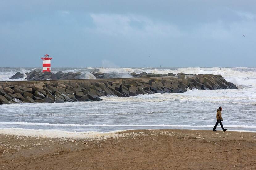 man op strand tijdens storm