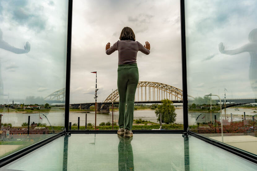 Vrouw kijkt vanbinnen naar buiten in Museum de Bastei