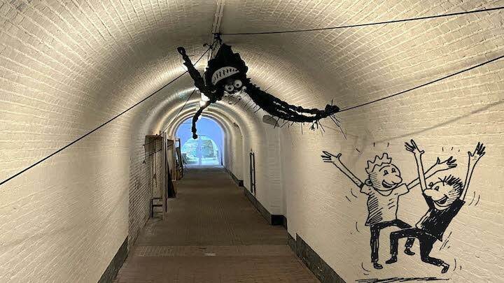 Een tunnel waarin een knuffel hangt en twee spelende kinderen getekend zijn