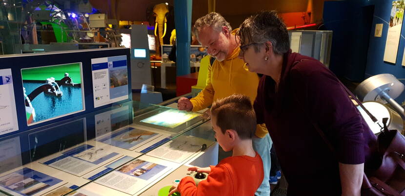 Een kind en twee volwassenen bekijken de expositie in het Nederlands Watermuseum