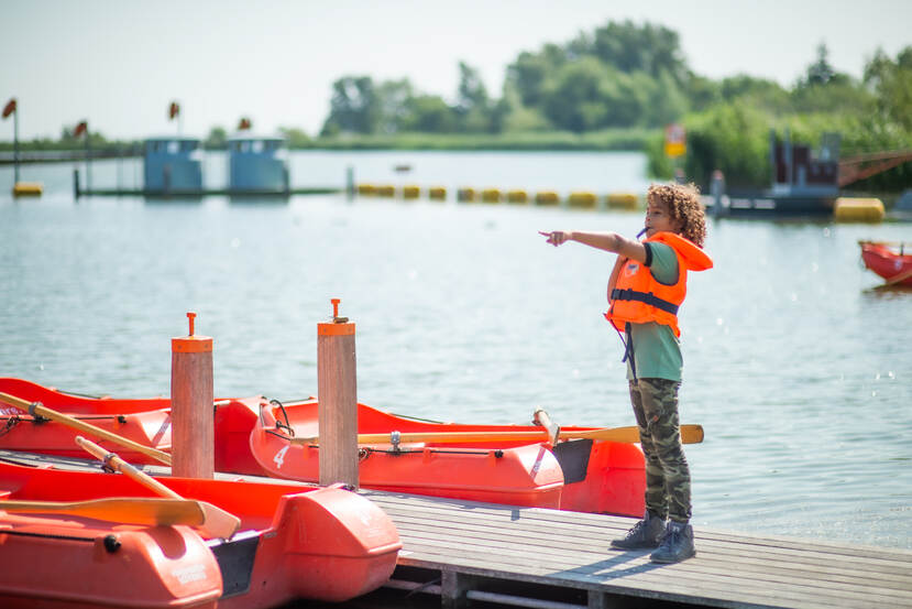 kind speelt bij roeiboten