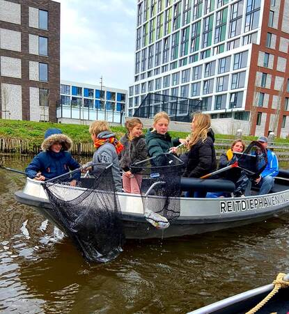 kinderen op boot met schepnet